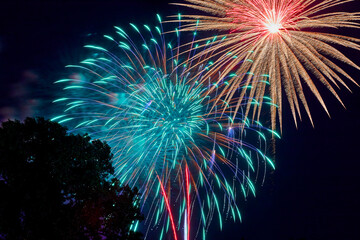 Fireworks filling the dark night with multiple explosions creating beautiful streaks across the...
