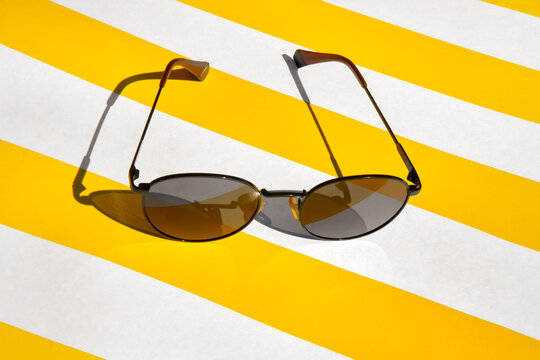Sunglasses on a Yellow and White Striped Background. 