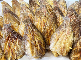 Deep fried Snakeskin gourami fish with spawns on white arches oil paper sheet