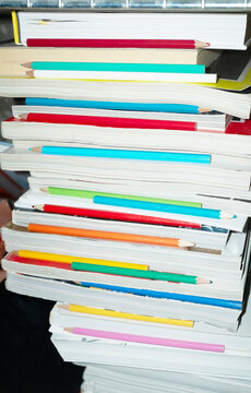 Tower of magazines and colorful pencils with hard direct flashlight