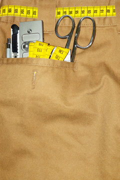 Trousers, measurement scale tape and silver metal tools in the pocket
