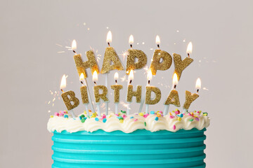 Happy birthday cake candles on a decorated birthday cake