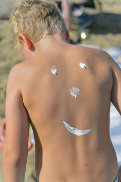 anonymous boy with a funny sunscreen smile 