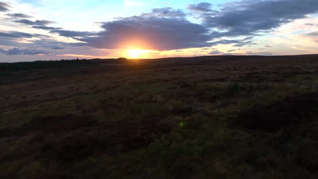 Sliabh Beagh, County Monaghan, Ireland, November 2022. Drone tracks low over wild bog land during golden hour on a warm winter evening.