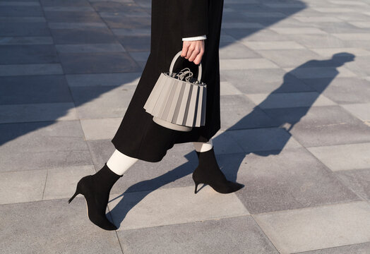 Fashionable Woman in Black Outfit with Stylish Handbag and High 