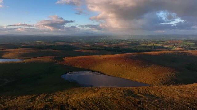 Bragan, County Monaghan, Ireland, September 2022. Drone gradually orbits clockwise around Lough na Heery on the Northern Ireland border with Lough Navarad in the background on a warm Autumn evening.