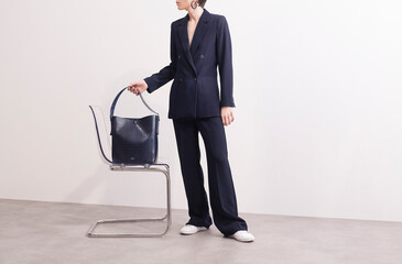 Fashionable Woman in Suit Holding a Designer Bag