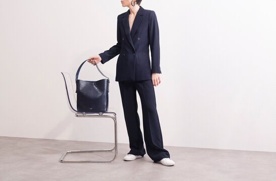 Fashionable Woman in Suit Holding a Designer Bag - Powered by Adobe