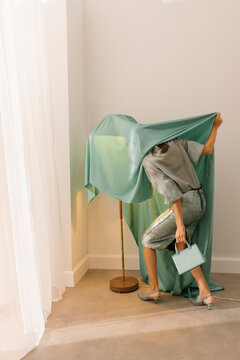 Fashionable Woman Draped in Green Fabric with Stylish Handbag