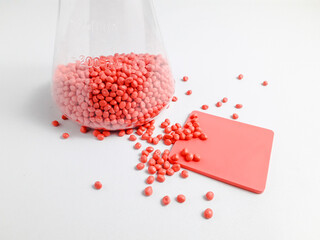 Soft pink masterbatch granules in erlenmeyer flask isolated on white background.Color pigment...