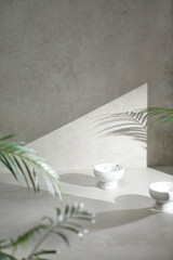 A gray-toned tile background with various props with sunlight coming through the window.