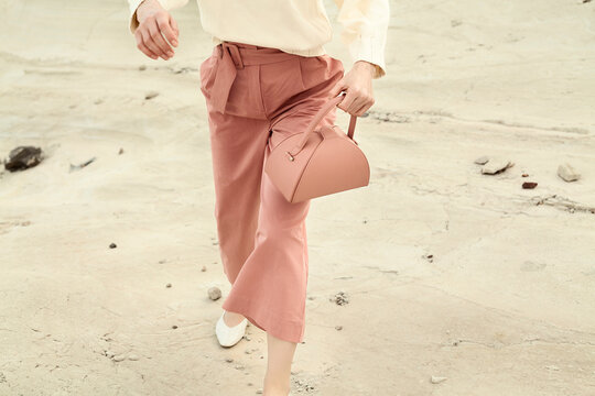 Fashionable Woman in Pink Pants Holding a Stylish Handbag
