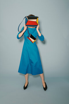Fashionable Woman In Blue Dress Holding Colorful Handbag