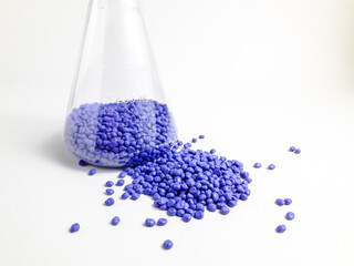 Blue masterbatch granules in Erlenmeyer flask and isolated on white background.Color pigment...