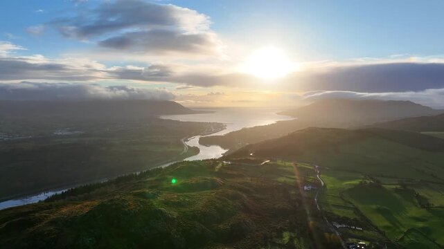 Flagstaff, County Down, Northern Ireland, November 2022. Drone tracks over rural farmland facing south east with Carlingford Lough Newry and Warrenpoint in the distance during the dawn sun rise.