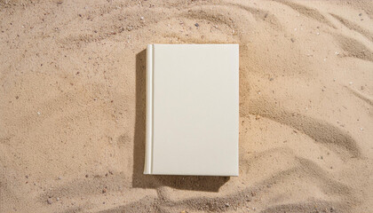 Closed white book for mockup on sand background