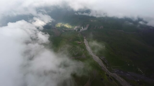 First-person view. Aerial view of a fall from the sky through the clouds in a mountainous area. Falling from Heaven