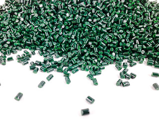 Forest green masterbatch granules on a white background. Color pigment carrier polymer in the...