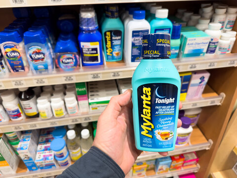 Bottle of Mylanta heartburn medicine inside a pharmacy.