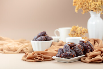 Dates in white dish on a beige background.
