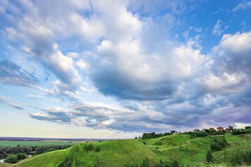 A cloudy sky with a hill in the background