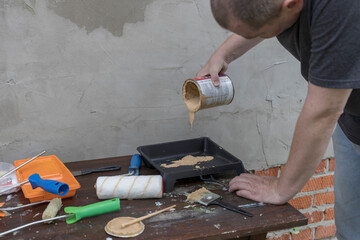 A man is painting a wall with a can of paint