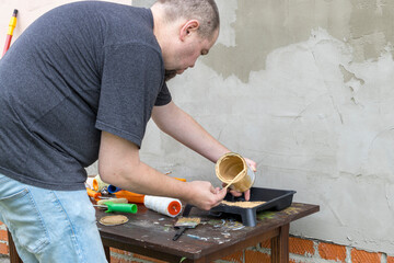 A man is painting a wall with a can of paint