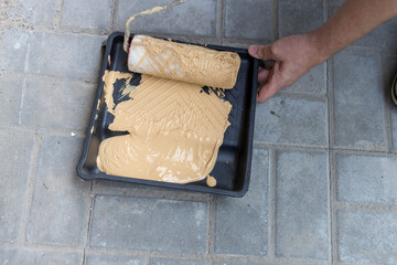 A person is painting a wall with a roller