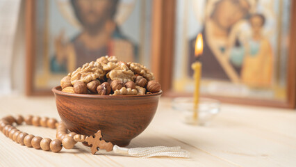 Orthodox food, Traditional food of Orthodox Christians. Nuts. Pottery. Orthodox rosaries and icons on the background, lit Orthodox candle.