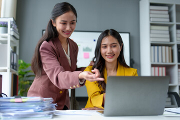 Fototapeta premium Two young businesswomen exchange ideas, presenting and analyzing marketing and investment plans on files. Discuss startup project ideas. Analyze planning and financial statistics at the office.