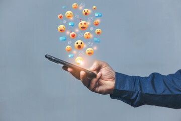 Hands holding and typing to communicate with others through emoji emotion. Online social communication,Social media,emotion, hearts. Chat Conversation on mobile. Man working using chatting application