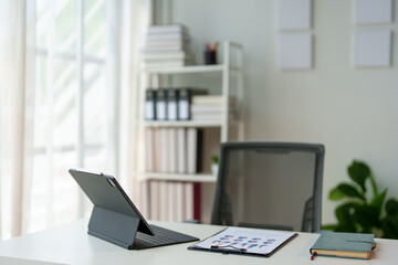 Stylish work area with laptop computer office supplies Files and books on shelves in the office Modern workplace concept.