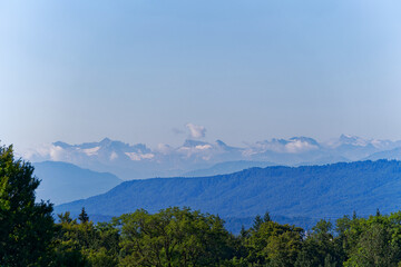 Panoramic landscape with Swiss Alps in the background seen from Dolder at Swiss City of Zürich on a sunny summer morning. Photo taken August 6th, 2024, Zurich, Switzerland.