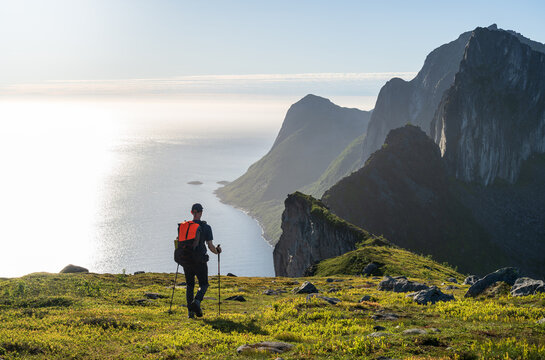 A hiker walking along the cliffs at coast on Senja, Norway.