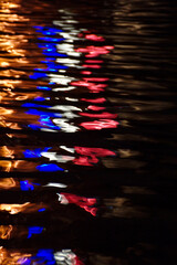 Reflection of coloured French colours in lights from a restaurant on the banks of the Seine in Paris