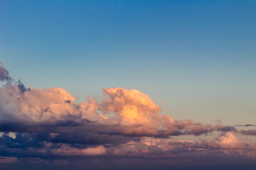 Fototapeta premium Dramatic clouds in the blue sky in the morning, the rising sun rays hitting the clouds