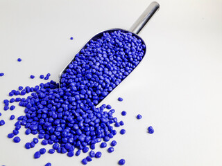 Azure blue masterbatch granules in scoop and isolated white background.Color pigment carrier...
