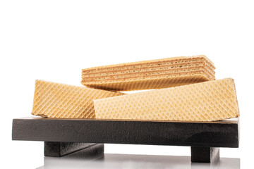 Several vanilla wafers on a black wooden tray, macro, isolated on white background.