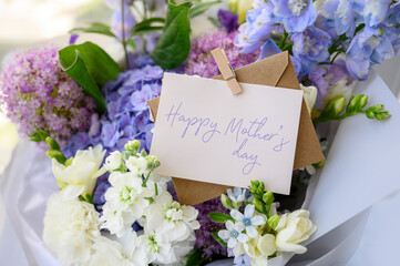 A bouquet of blue hydrangea, freesia close-up. Happy Mother's Day text. bouquet with delicate...