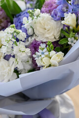 a beautiful freshly cut bouquet of mixed flowers. Bouquet of fresh hydrangeas, freesia, carnations, Allium Flowers in blue and pastel colors