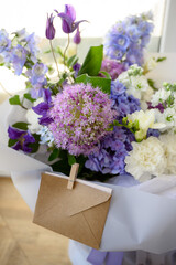 kraft envelope in a bouquet. a beautiful bouquet close-up with an envelope for a note.