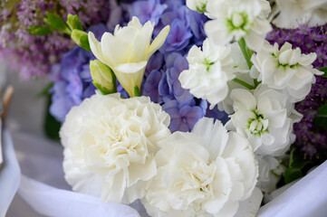 a beautiful freshly cut bouquet of mixed flowers. Bouquet of fresh hydrangeas, freesia, carnations, Allium Flowers in blue and pastel colors