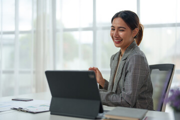 Young Asian businesswoman uses a calculator to calculate business principles. Accounting statistical concepts at the office starting a financial business, calculating accounting online marketing.