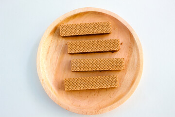 Chocolate waffles on wooden plate isolated on white background. Crispy snack dessert. Food Photography Concept