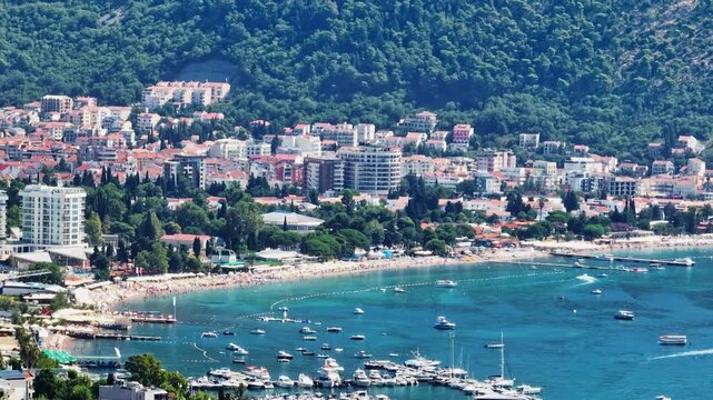 Telephoto drone shot of the coastline of Budva city, sunny day in Montenegro