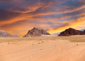 Wadi Rum Desert also known as The Valley of the Moon (against the sky with clouds)-- is a valley cut into the sandstone and granite rock in southern Jordan 60 km to the east of Aqaba