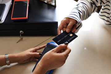 Close Up Female Customer Paying with Black Credit Card