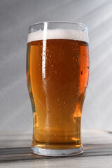 Glass of beer on grey wooden table