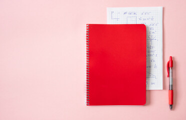 Back to school, education concept, Red notebook with math formulas paper with pen on pink background