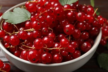 Fresh red currants in bowl on table, closeup